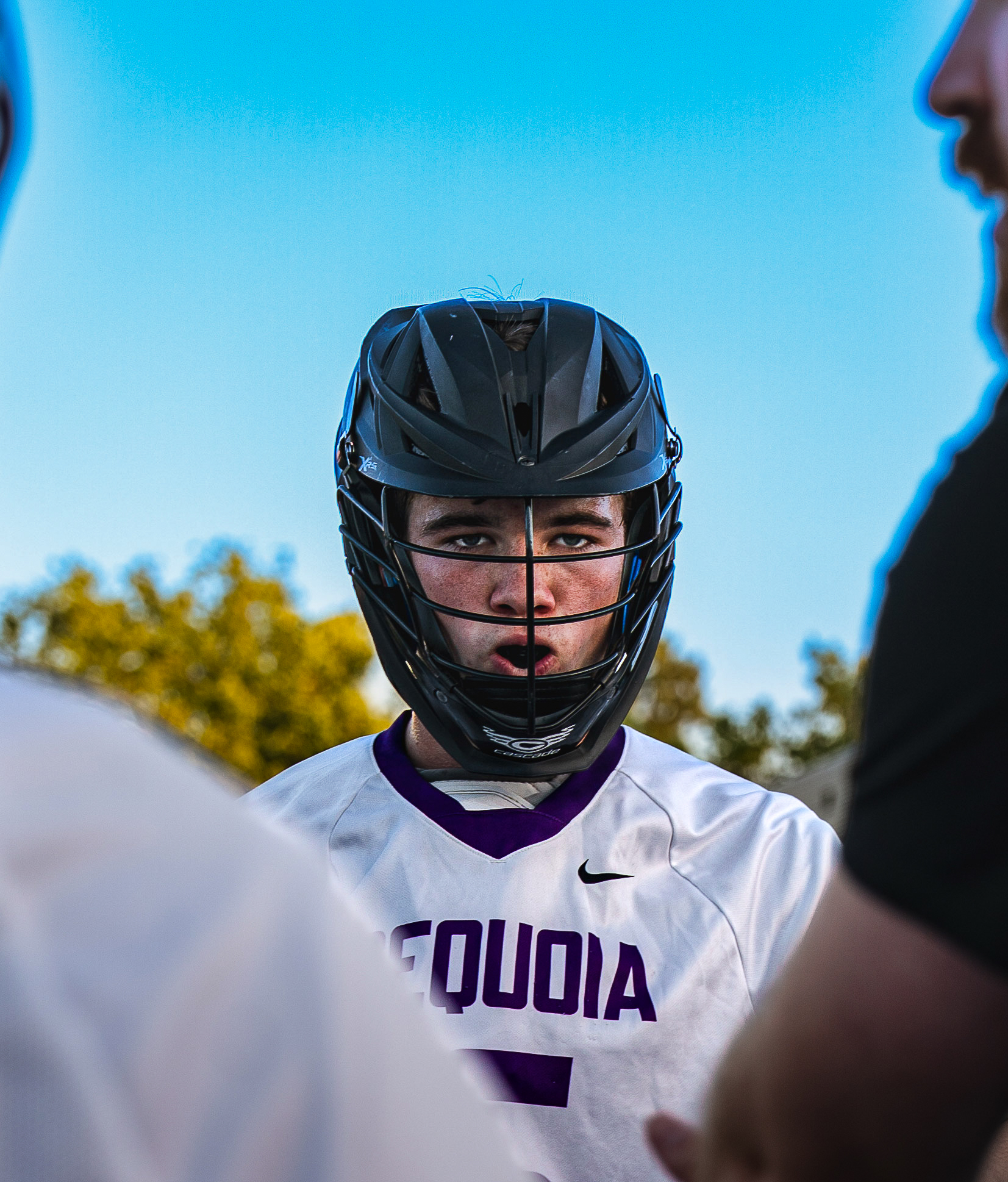 Lacrosse player in the huddle at golden hour